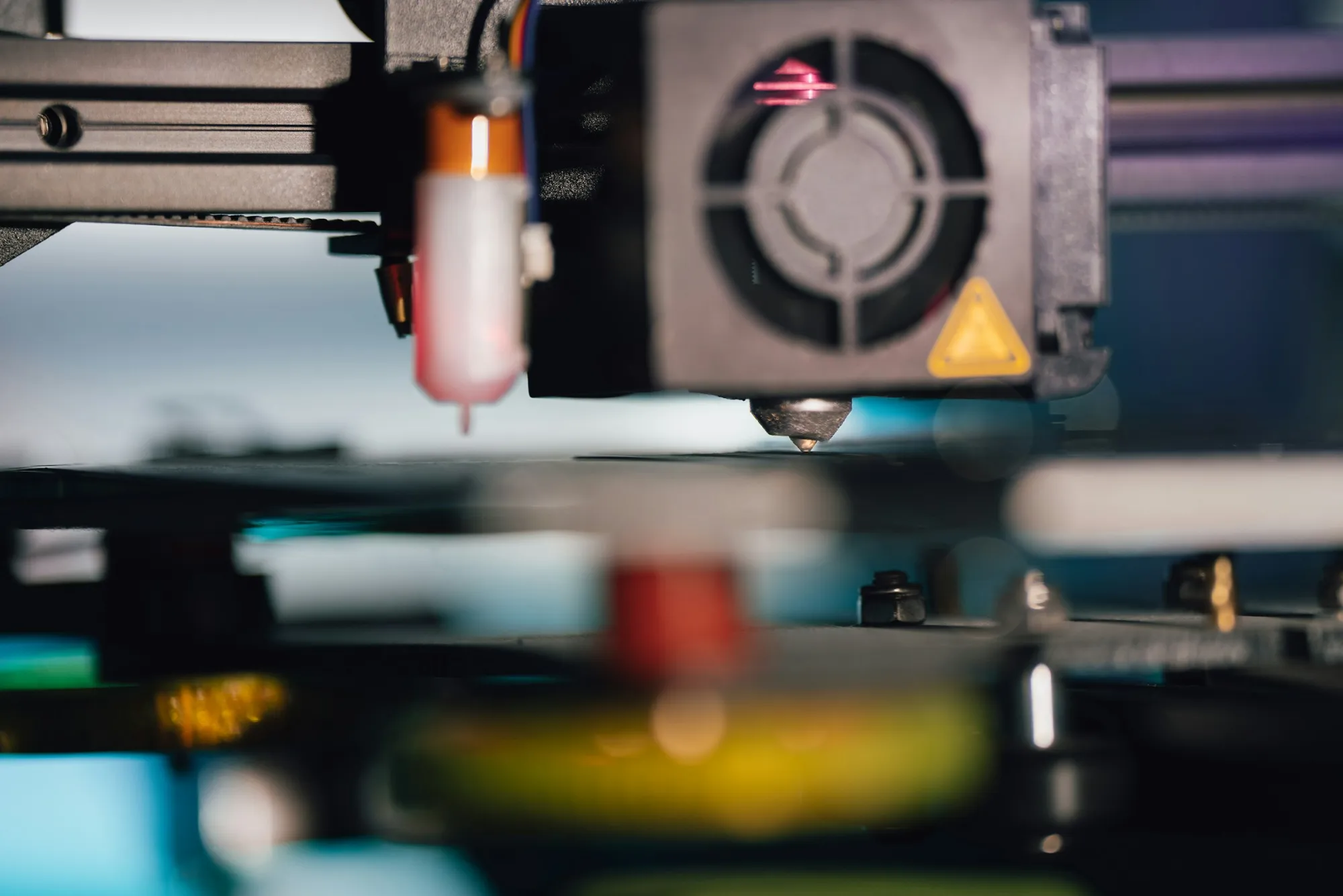Close-up of a 3D printer nozzle depositing material with precision