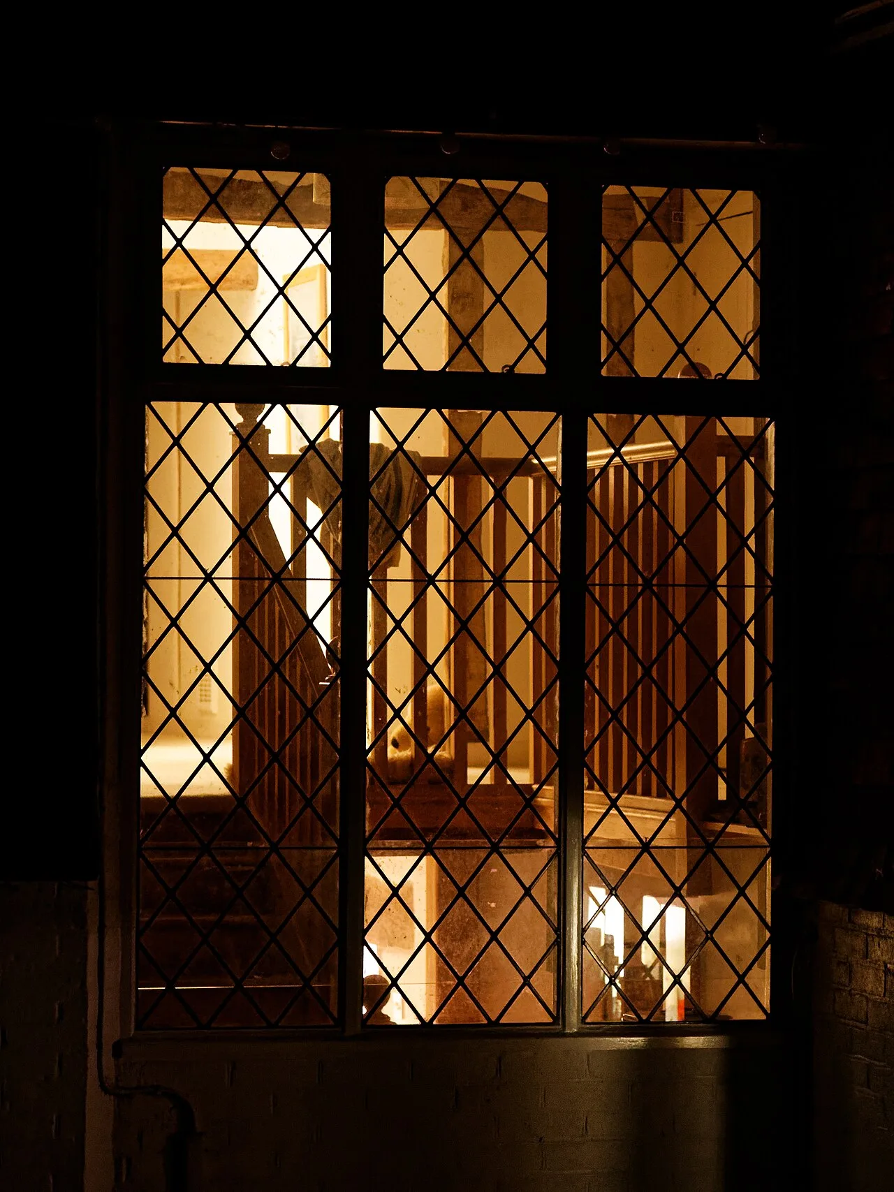 Warm light glowing through a cottage window at night