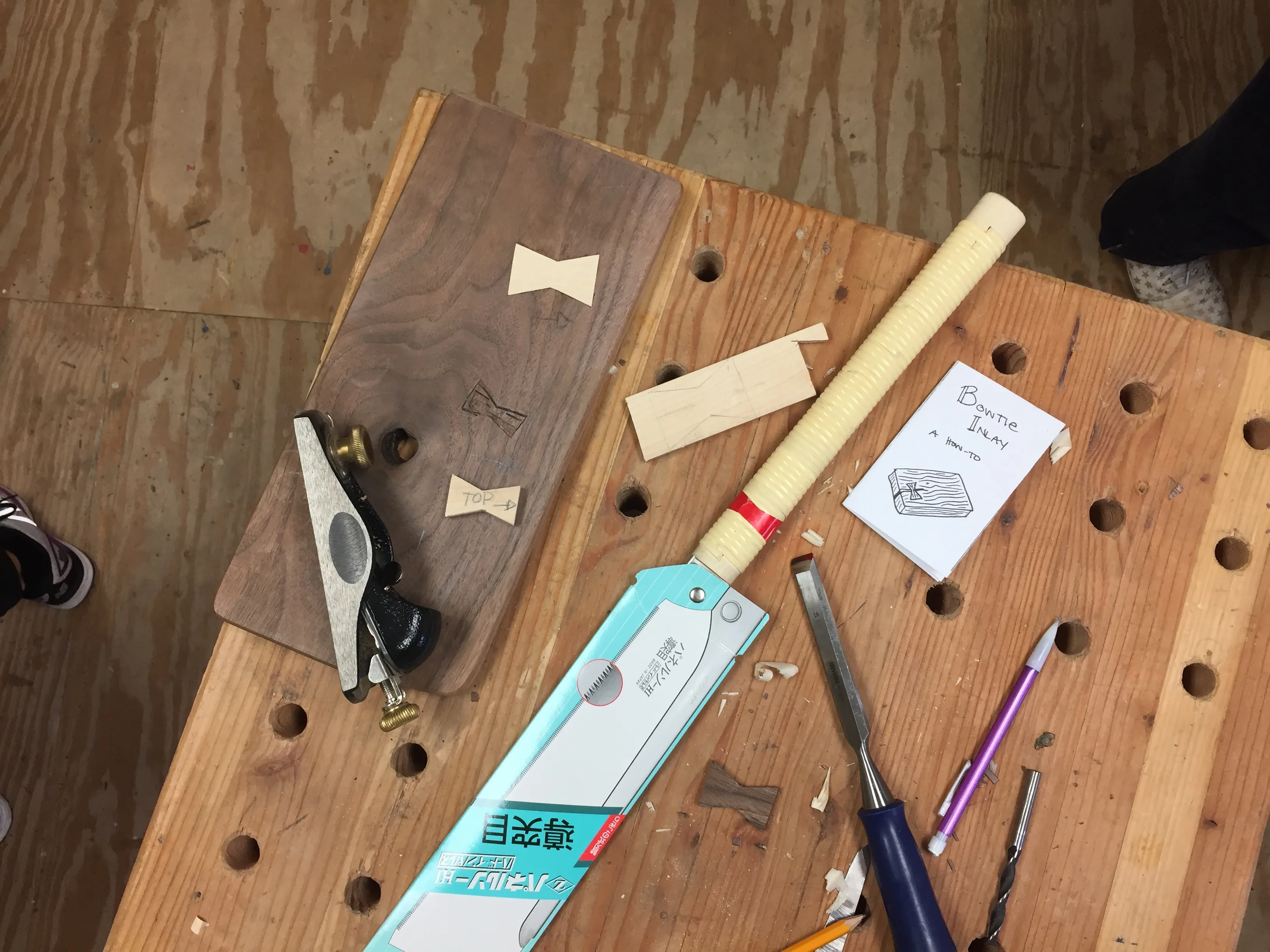 Woodworking tools laid out across a scarred workbench