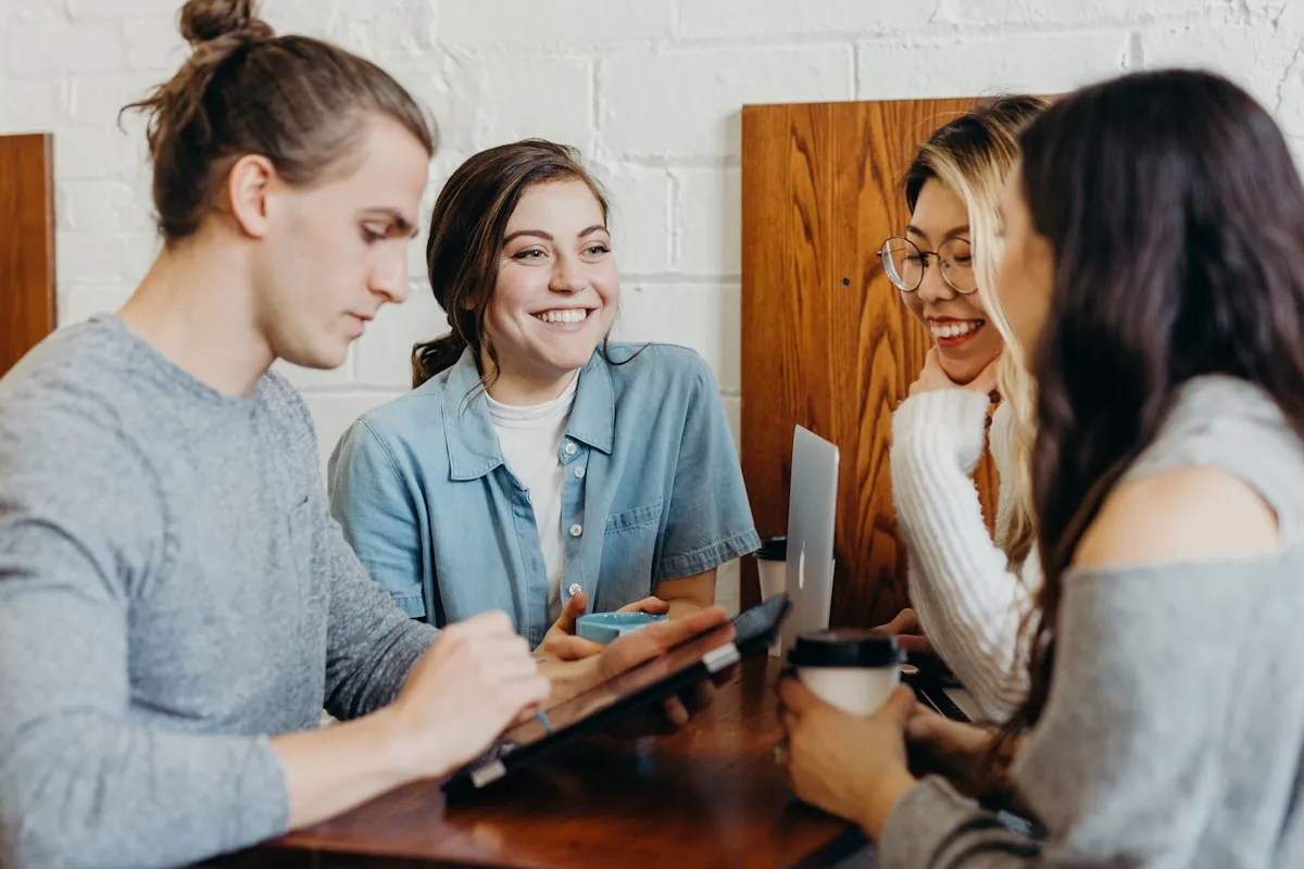 Friends gathered around a cafe table, sharing conversation and coffee