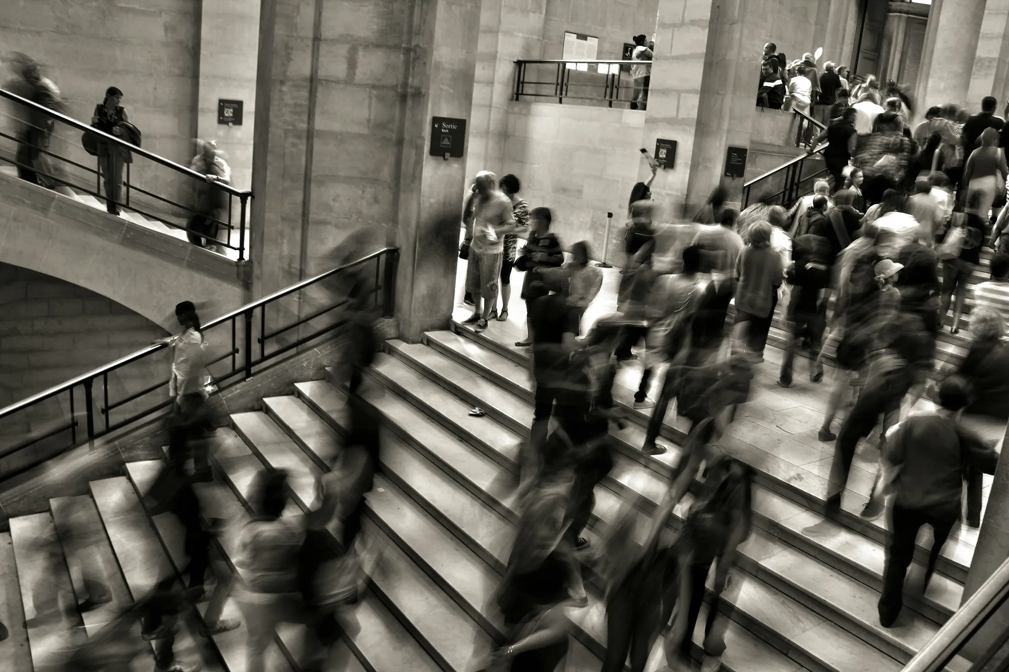 Blurred crowd rushing up and down a grand staircase